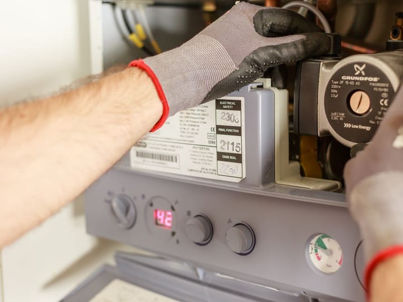 Gas Safe engineer servicing the internal components of a domestic boiler in Romford